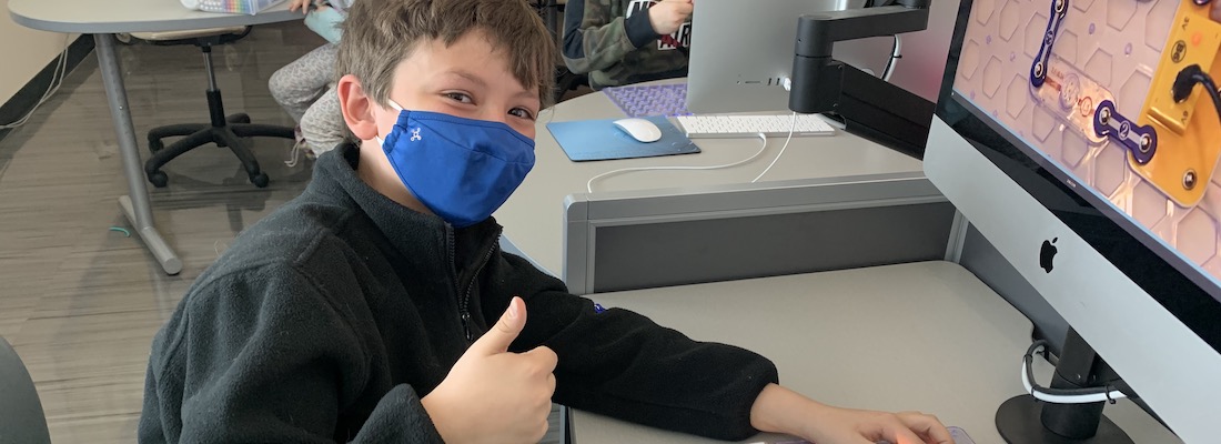 Student posing in front of the computer
